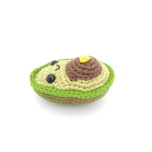 amigurumi de aguacate niño acostado boca arriba
