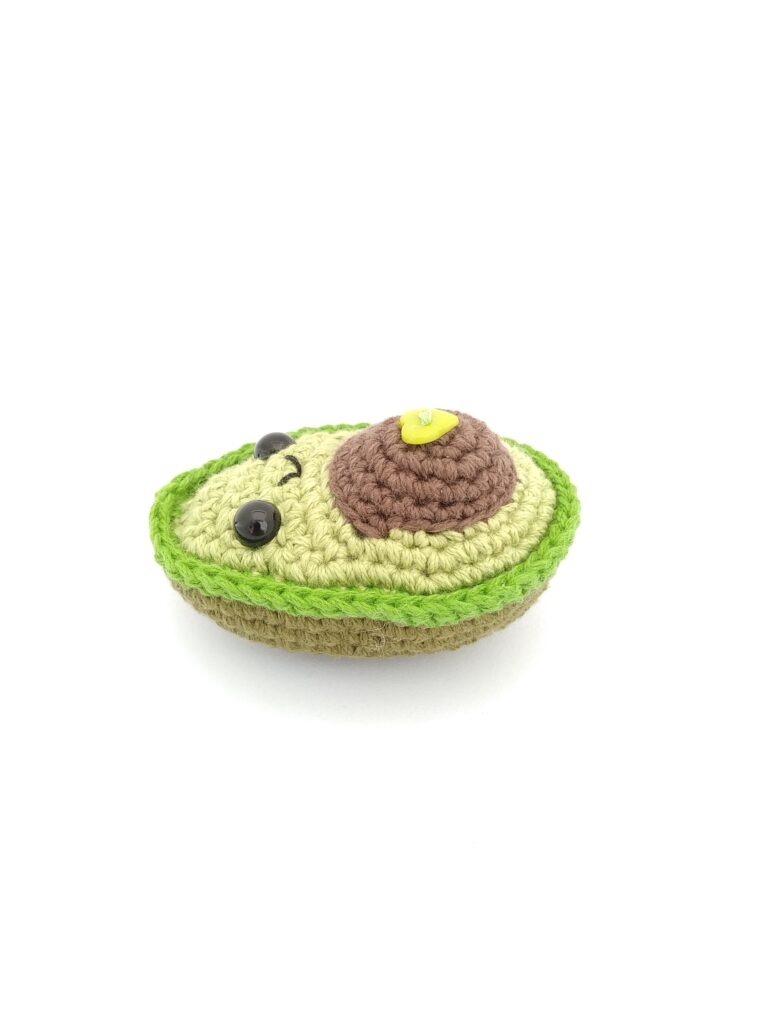 amigurumi de aguacate niño acostado boca arriba